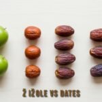 Fresh žižole fruits on a wooden table, showcasing their vibrant red and green colors.
